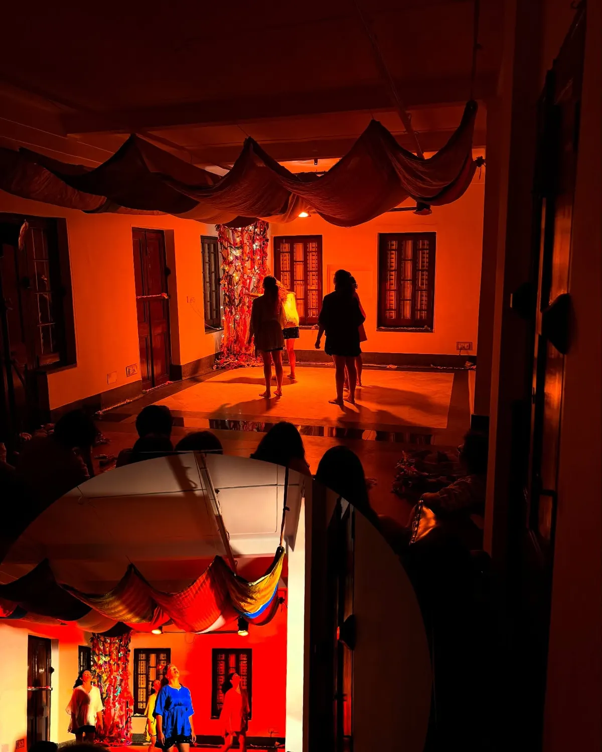 Ceremony of Longing poster, a figure seen through a circular cut in red cloth.