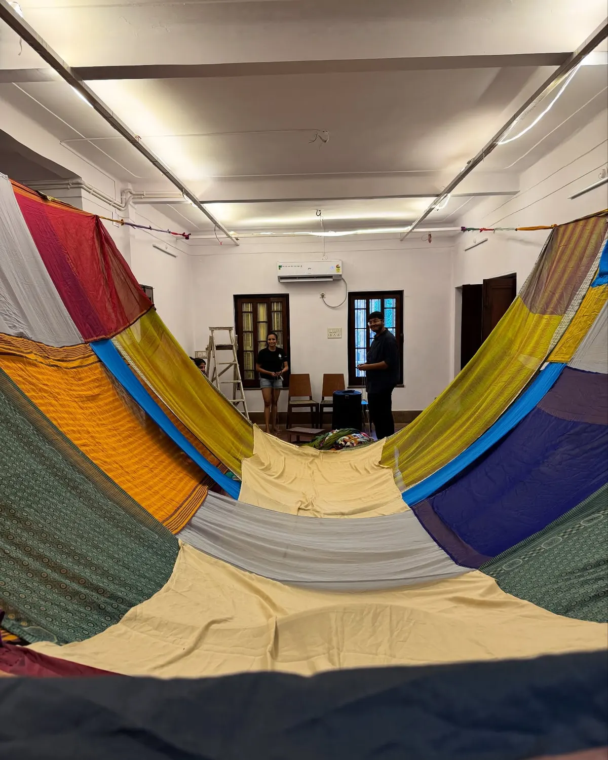 The studio draped in coloured saris from the ceiling.