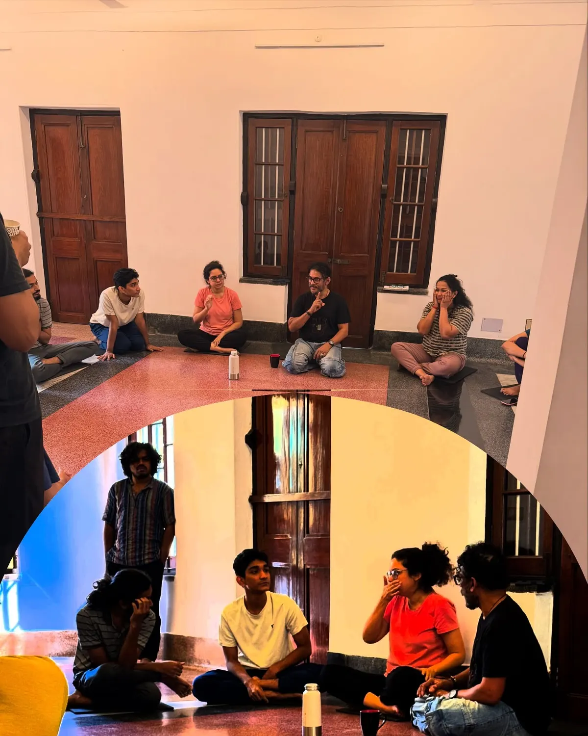 A workshop in the studio: participants sit in a circle on the floor between the teak doors.